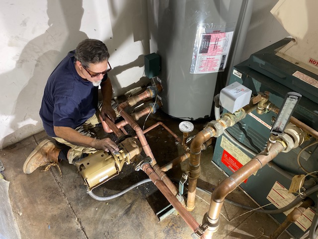 Adrian working on the piping of the water heater.